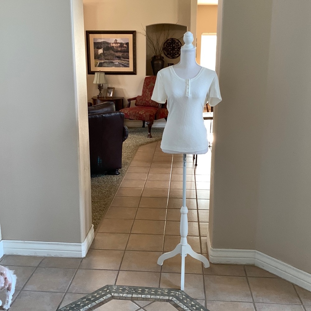 Cream colored T-shirt with four buttons down the front